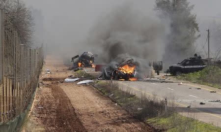 Burning vehicles are seen near the village of Ghajar on Israel's border with Lebanon January 28, 2015. REUTERS/Maruf Khatib