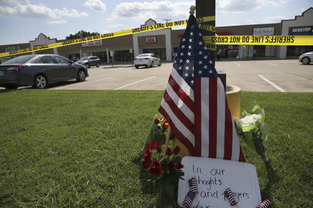 Police tape and a makeshift memorial sit on the lawn in front of an Armed Forces Career Center in this handout photo provided by the U.S. Navy, where earlier in the day a gunman opened fire, injuring one U.S. Marine in Chattanooga, Tennessee, July 16, 2015, REUTERS/Damon J. Moritz/U.S. Navy/Handout via Reuters