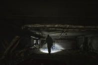 A Ukrainian serviceman inspects a kindergarten basement which was used by Russian forces in the recently liberated village of Kapitolivka near Izium, Ukraine, Sunday, Sept. 25, 2022. Based on accounts of survivors and police, Associated Press journalists located 10 torture sites in the town and gained access to five of them, including the kindergarten. (AP Photo/Evgeniy Maloletka)