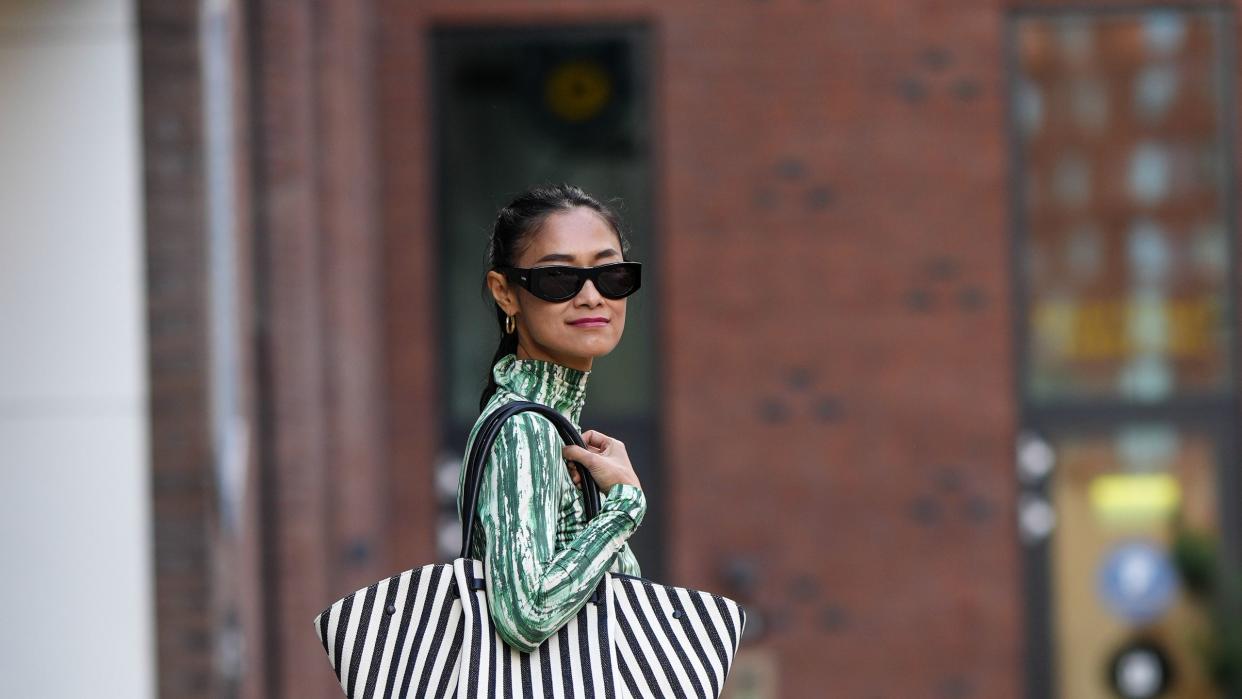 a woman wears a striped bag in a guide to the best gifts under $20