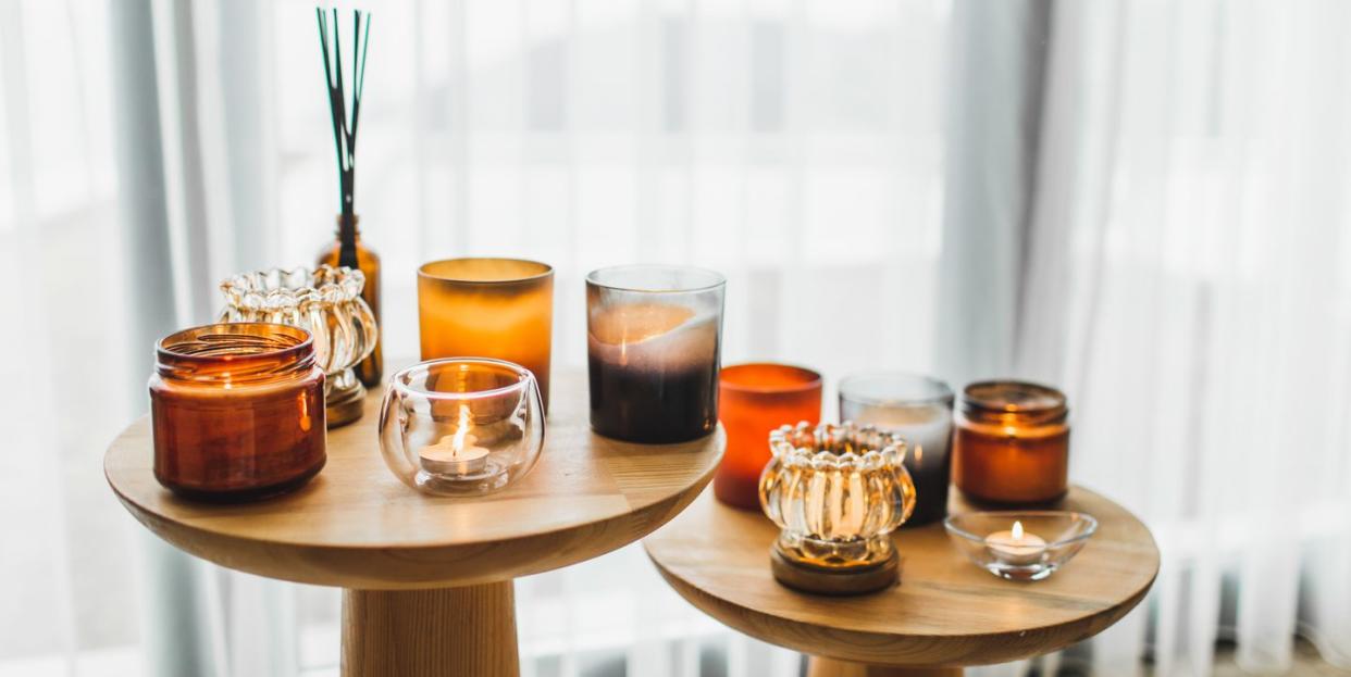 scented candles in different candlelights on wooden table at home