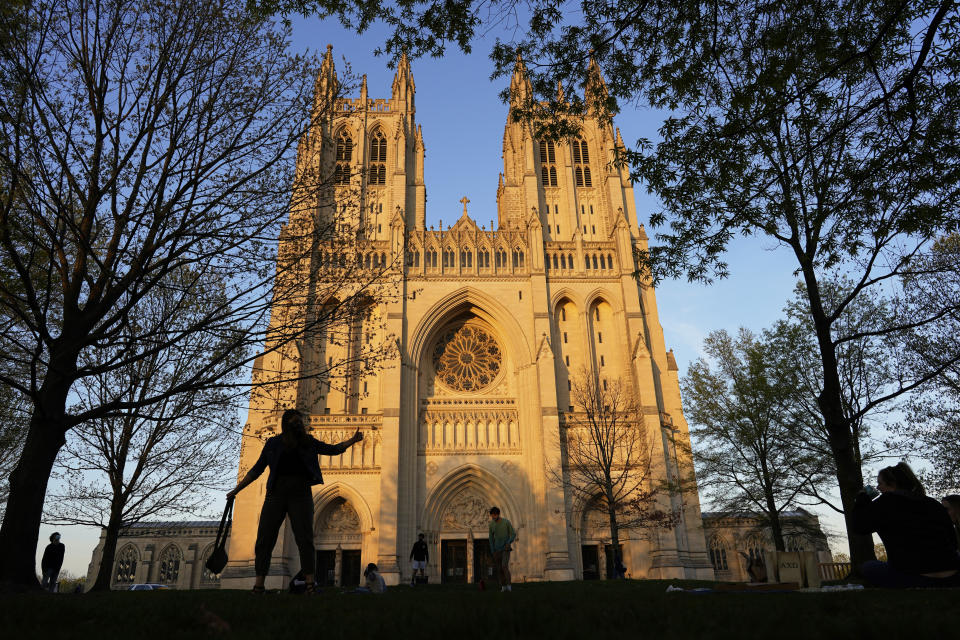 FILE - This Tuesday, April 13, 2021 file photo shows the Washington National Cathedral is seen at sunset. Washington National Cathedral has chosen contemporary artist Kerry James Marshall, renowned for his wide-ranging works depicting African-American life, to design new stained-glass windows with themes of racial justice to replace windows with Confederate imagery that were removed from the landmark sanctuary in 2017. (AP Photo/Carolyn Kaster)