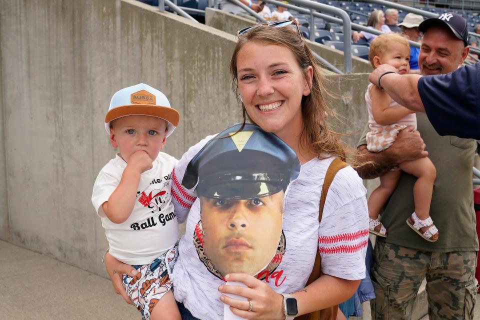 Amanda Spooner poses for a photo with her son Greyson, 1, and a picture of New Jersey State Police Detective Miguel Hidalgo during the Battle of the Badges charity softball game at Skylands Stadium on Thursday, August 3, 2023. Hidalgo, who signed a one-day contract with the Sussex County Miners, is donating his salary to help purchase a specialized wheelchair for Spooner's 11-year-old nephew, Cash.