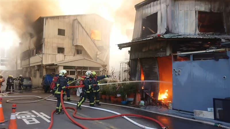 火勢延燒波及附近民宅，消防隊員急拉水線灌救，幸好火勢已控制住。（圖／翻攝畫面）