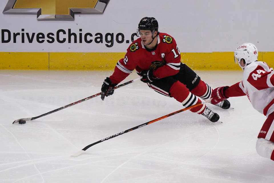 Chicago Blackhawks left wing Alex DeBrincat, left, looks to pass against Detroit Red Wings defenseman Christian Djoos during the second period of an NHL hockey game in Chicago, Saturday, Feb. 27, 2021. (AP Photo/Nam Y. Huh)