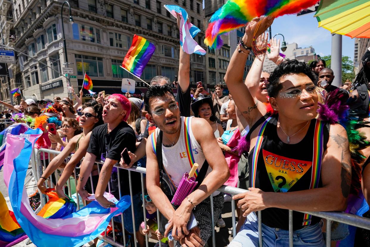 Spectators watch as revelers march down Fifth Avenue during the annual NYC Pride March on Sunday.