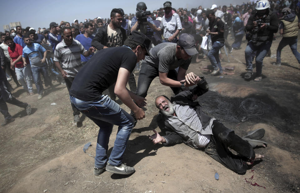 An elderly Palestinian man falls on the ground after being shot by Israeli troops during a deadly protest at the Gaza Strip's border with Israel, east of Khan Younis, Gaza Strip, Monday, May 14, 2018. (AP Photo/Khalil Hamra)