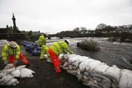 Council workers rebuild a wall with sandbags following flooding at Newton Stewart in Scotland, Britain December 31, 2015. REUTERS/Darren Staples