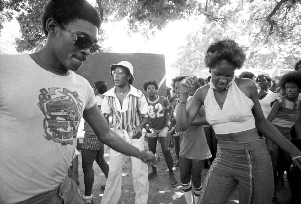 A group of people are seen dancing to music at Sycamore Park in Fort Worth during Juneteenth festivities in 1977.