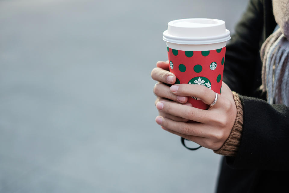 Woman hands holding hot Starbucks coffee paper cup, for Christmas and Happy New Year collection. Kunming, China, December 10, 2019