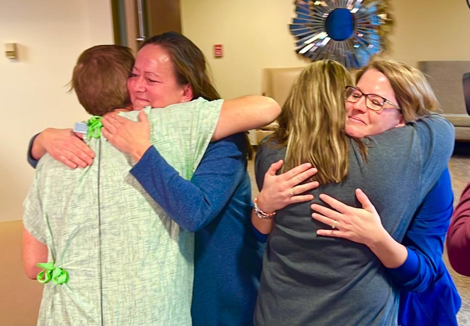 Tim Wright, left, hugs nurse Wendy Rockey and Jayda Hollander greets Amber Burke, right, at Iowa Methodist Medical Center.