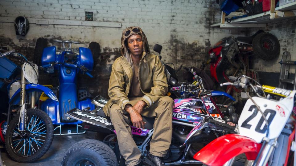 a man sitting on a red and white motorcycle