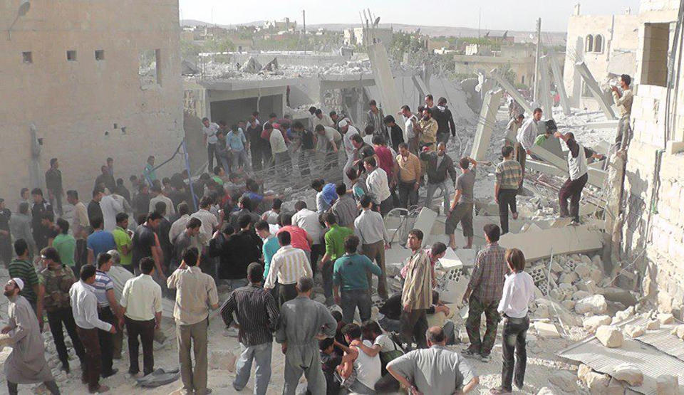 In this Wednesday, Oct. 17, 2012 photo, citizen journalism image provided by Edlib News Network, ENN, which has been authenticated based on its contents and other AP reporting, Syrian citizens gather to rescue people from under the rubble of a building that was destroyed from a Syrian force airstrike, at Kfar Nebel town, in Idlib province, northern Syria. (AP Photo/Idlib News Network ENN)