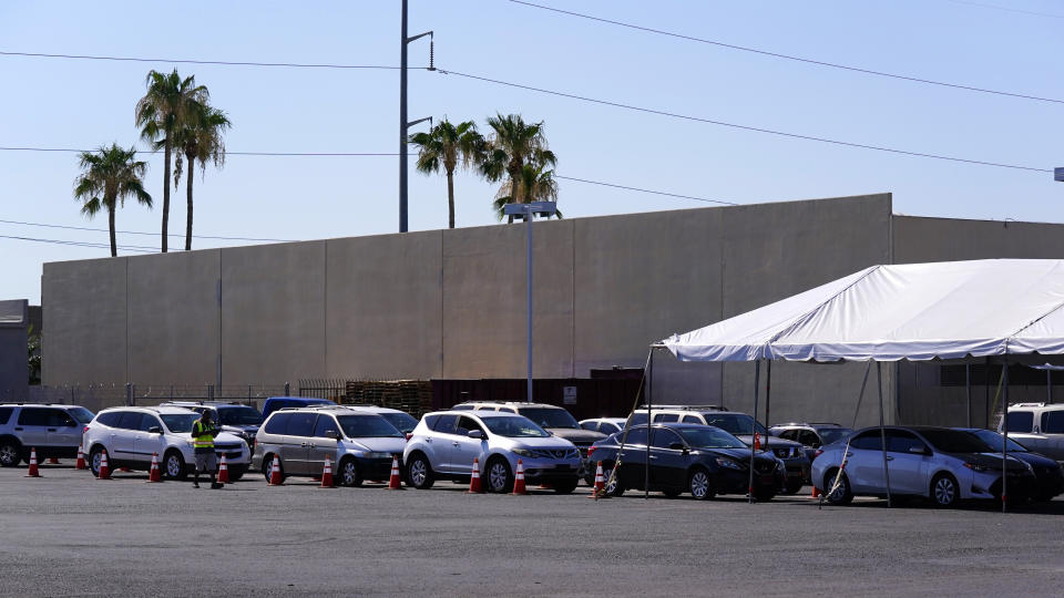 Dozens of vehicles line up to get food boxes at the St. Mary's Food Bank Wednesday, June 29, 2022, in Phoenix. Long lines are back at outside food banks around the U.S. as working Americans overwhelmed by inflation increasingly seek handouts to feed their families. Many people are coming for the first time amid the skyrocketing grocery and gas prices. (AP Photo/Ross D. Franklin)