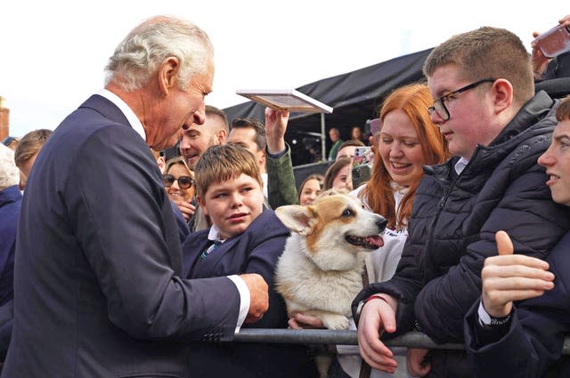 Charles meets a woman holding a corgi