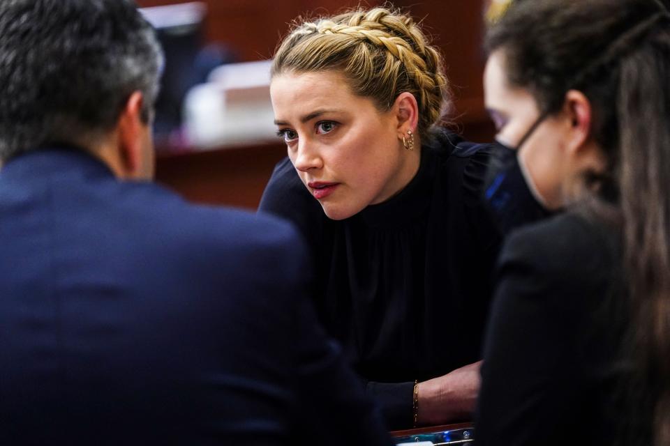 Amber Heard leans in to hear her legal team in court on 14 April (POOL/AFP via Getty Images)