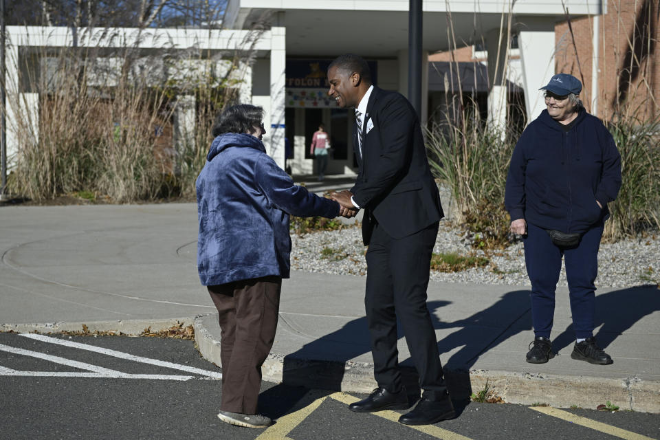 Republican House candidate George Logan greets voter Jean Goering, left, as friend Lee Vojtila, right, looks on outside Louis Toffolon Elementary in Plainville, Conn., Tuesday, Nov. 8, 2022. Logan is running against U.S. Rep. Jahana Hayes in Connecticut's fifth congressional district. (AP Photo/Jessica Hill)