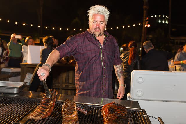 <p>Dylan Rives/Getty</p> Guy Fieri mans the grill in 2016.