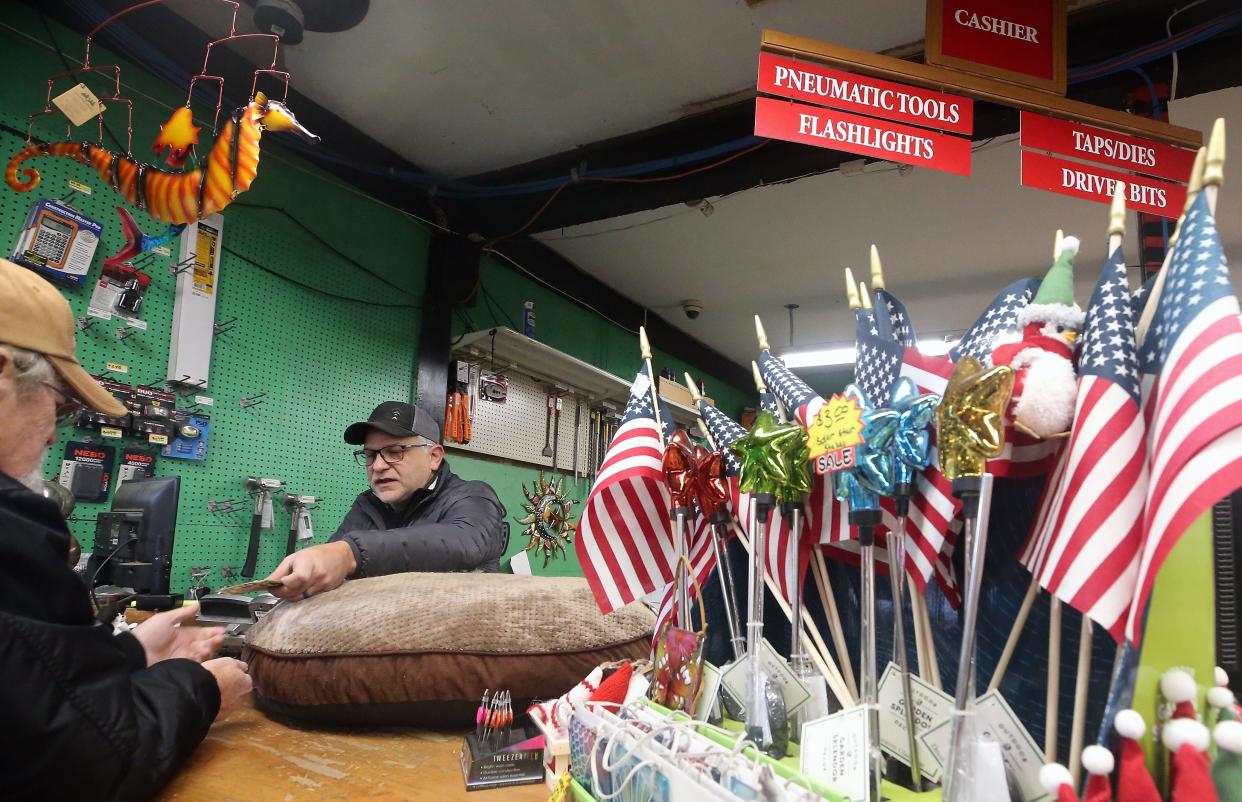 Kitsap Lumber & Hardware owner Shane Hickey hands a customer their change after they purchased a dog bed at the counter of the store on Nov. 29.