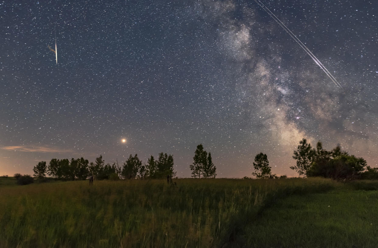 A busy sky with bright red Mars rising east of the Milky Way, while a pair of Iridium satellites flare briefly as they travel in unison up along the Milky Way from south to north.   About 20 minutes later a very bright meteor flared and produced a lasting train of smoke, seen at left and composited in from two later frames - but with it located where it appeared, above Mars. But to be clear - the meteor did not appear at the same time as the Iridiums. Nevertheless, this captures the fact that there were a lot of satellites and meteors this night, on a very clear though short summer night. It was a busy sky!