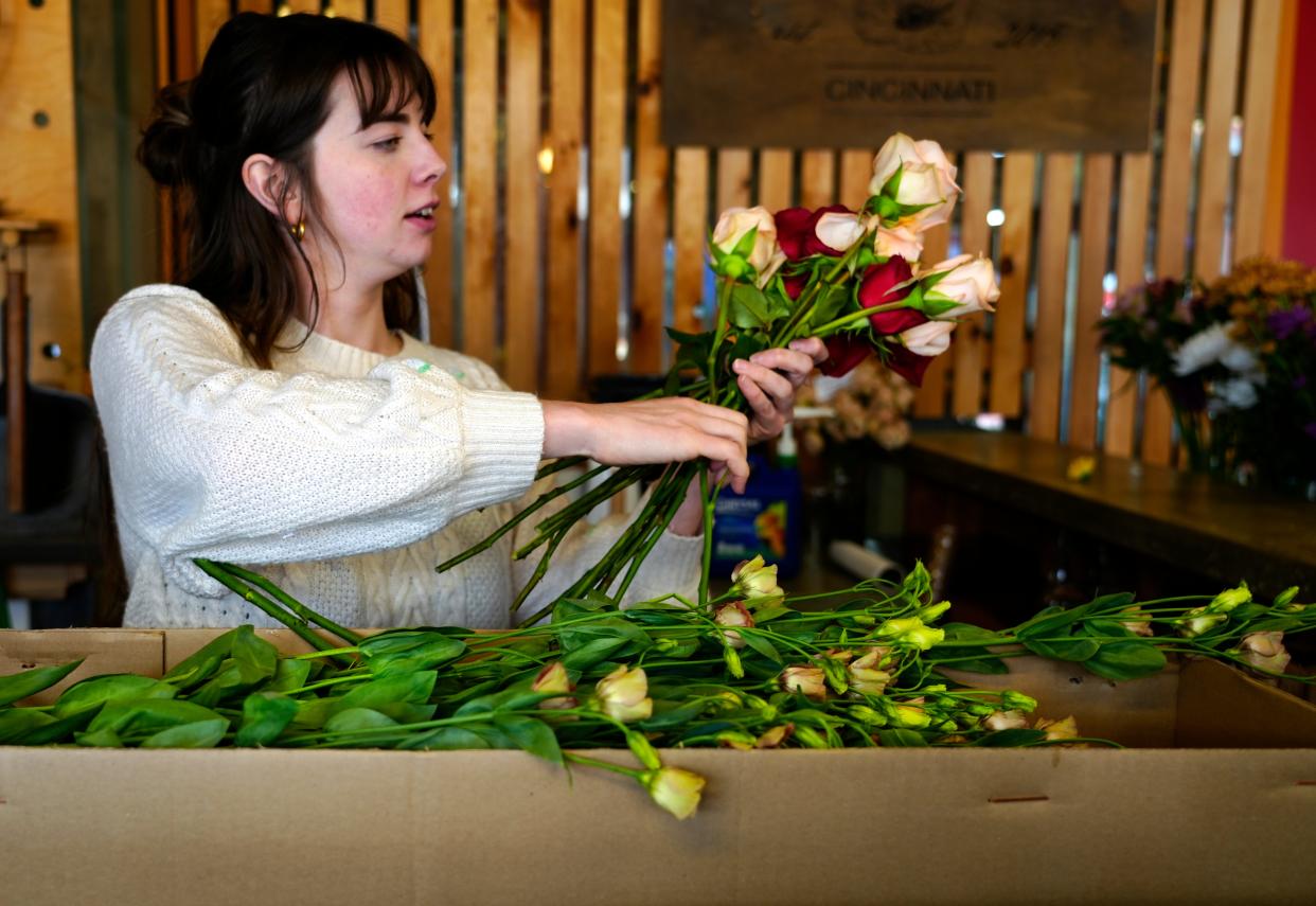 Claire Greweling, a florist with Gia & the Blooms, arranges fresh flowers at their stall in Findlay Market in Over-the-Rhine, Thursday, Dec. 14, 2023.