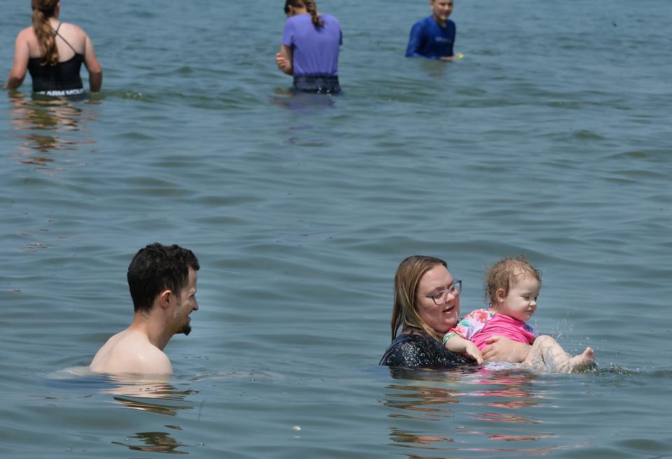 Justin Driscoll, 24, left, swims with his girlfriend Jessica Word, 24, and their daughter Serena Driscoll, 2, at Presque Isle State Park Beach 6 in Millcreek Township on July 20. Swimmers were allowed back in the waters of Beach 6 after being prohibited since July 11 due to high bacteria levels.