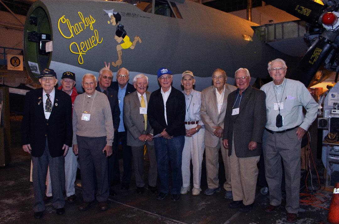 World War II veterans with connections to the B-26 Marauder bomber pose in 2014 at a B-26 Marauder Historical Society reunion at MAPS Air Museum. The B-26 bomber behind them since has been fully restored for display.