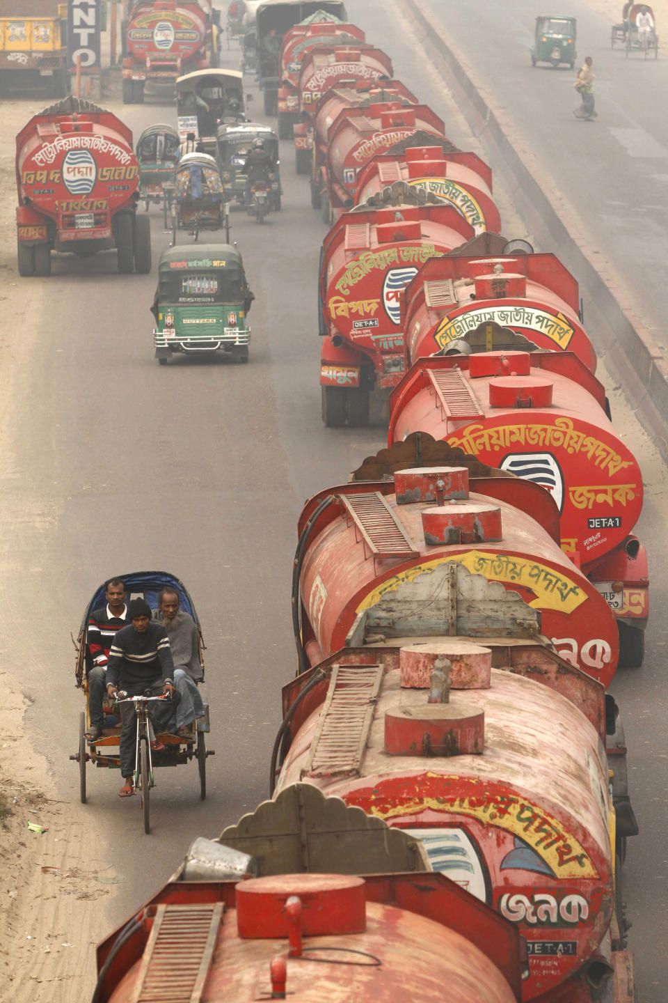 Police escort a convoy of oil tankers during a 48-hour general strike called by the opposition to protest Sunday's election, in Dhaka, Bangladesh, Monday, Jan. 6, 2014. Bangladesh's ruling Awami League won one of the most violent elections in the country's history, marred by street fighting, low turnout and a boycott by the opposition that made the results a foregone conclusion. (AP Photo/ Rajesh Kumar Singh)