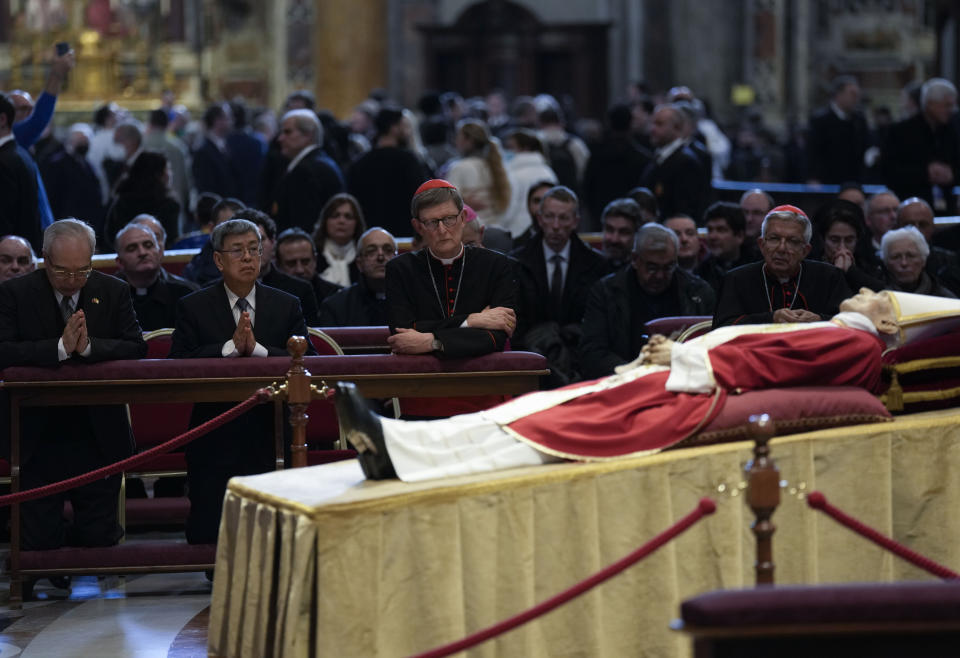 FILE - Former Taiwan's Vice-President Chen Chien-jen, second from left, prays in front of the body of late Pope Emeritus Benedict XVI, his head resting on a pair of crimson pillows, lying in state in St. Peter's Basilica at The Vatican, Wednesday, Jan. 4, 2023. The attendance of both the former bishop of Hong Kong and an advisor to Taiwan's leader at this week's funeral for Pope Emeritus Benedict XVI highlights the Vatican's uneasy relationship with communist-ruled China. (AP Photo/Antonio Calanni, File)