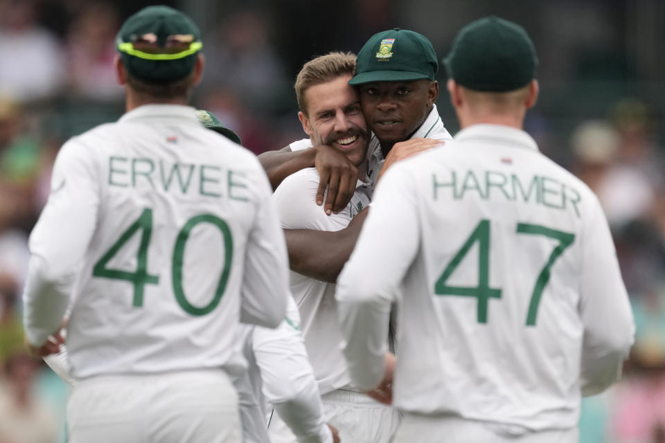 South Africa's Anrich Nortje, center right, celebrates with teammate Kagiso Rabada after taking the wicket of Australia's David Warner on the first day of their cricket test match at the Sydney Cricket Ground in Sydney, Wednesday, Jan. 4, 2023. (AP Photo/Rick Rycroft)