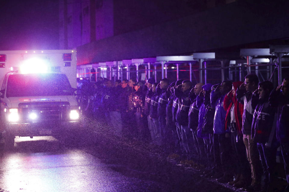 Officers salute a procession as the remains of slain Detective Brian Simonsen are removed from Jamaica Hospital Tuesday, Feb. 12, 2019, in the Queens borough of New York. The NYPD detective and a NYPD sergeant were shot while responding to an armed robbery at a T-Mobile store in Queens. (AP Photo/Kevin Hagen).