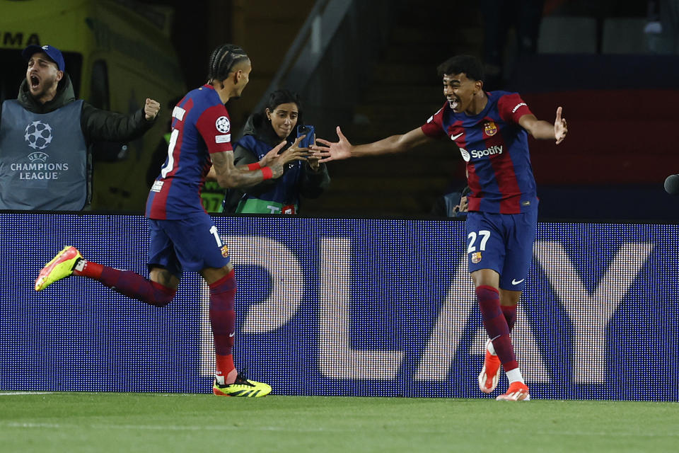 Barcelona's Raphinha, left, celebrates with Barcelona's Lamine Yamal after scoring the opening goal during the Champions League quarterfinal second leg soccer match between Barcelona and Paris Saint-Germain at the Olimpic Lluis Companys stadium in Barcelona, Spain, Tuesday, April 16, 2024. (AP Photo/Joan Monfort)