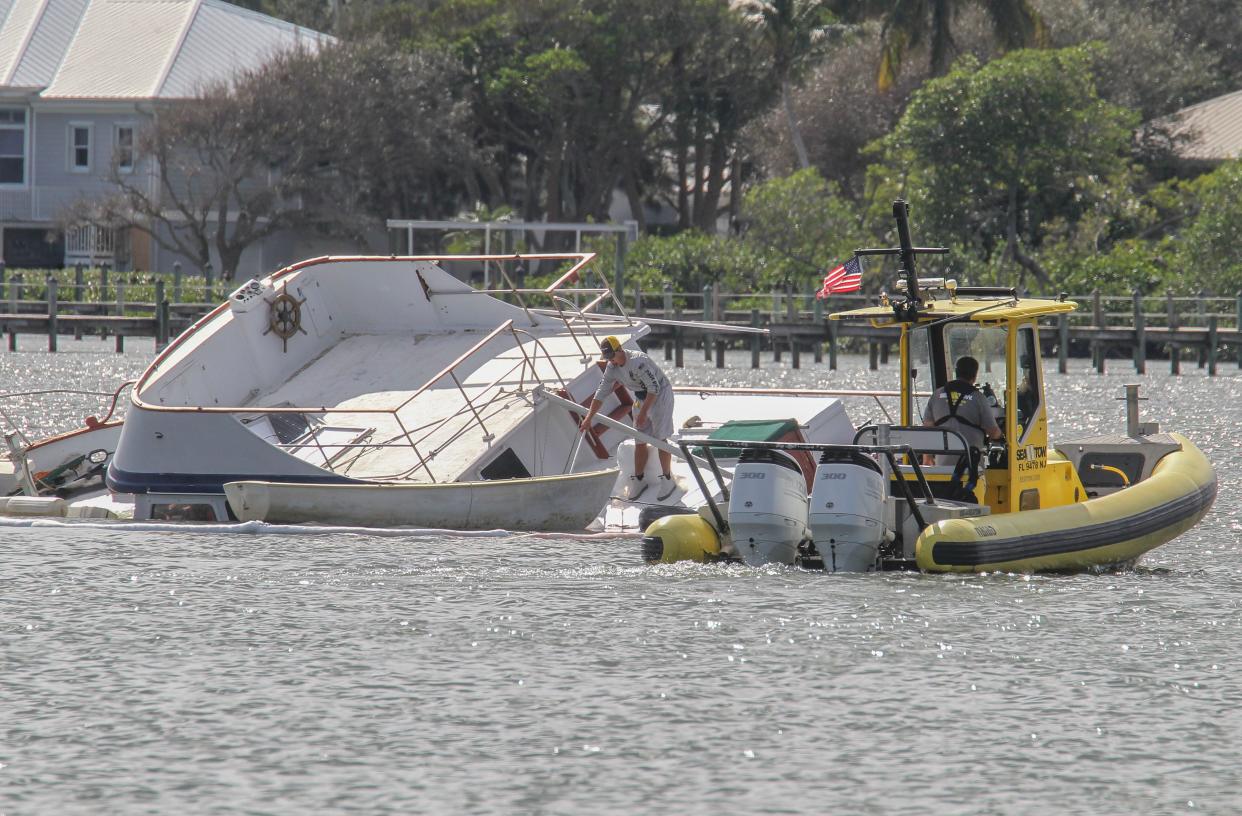 Sea Tow crew members Noll Stieren (left) and Ken Dion prepare to secure an absorption boom around a trawler vessel leaking diesel fuel into the Indian River lagoon on Friday, Nov. 17, 2023, in Stuart.