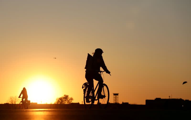 FILE PHOTO: People on bikes enjoy the sunset at the Tempelhofer Feld in Berlin