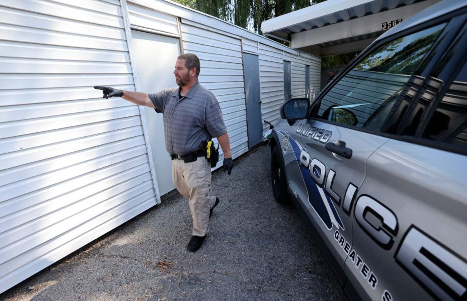 Unified police detective Joe Ball looks for a storage unit to search after two people were taken into custody for their suspected involvement in an odometer scam in South Salt Lake on Wednesday.