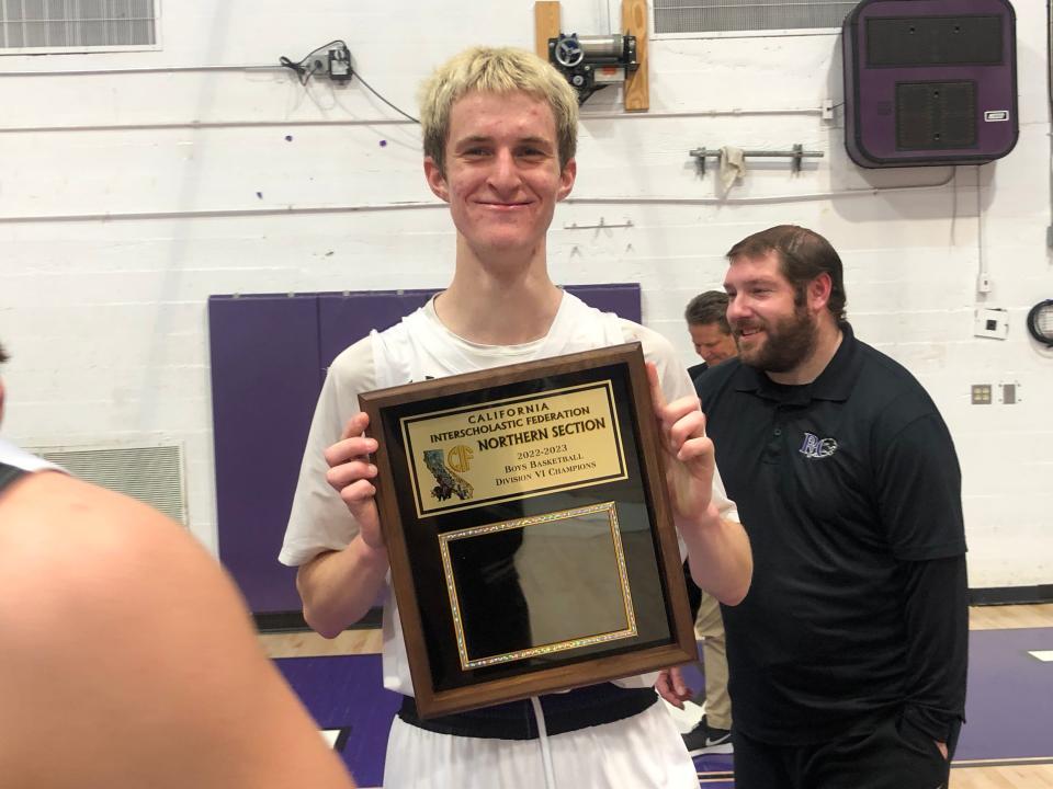 Redding Christian senior Joey Casey (center) holds the CIF Northern Section Division VI title plaque on Feb. 24, 2023 at Shasta High School.