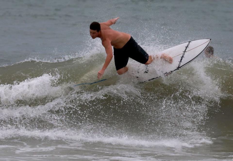 A surfer navigates the waves at St. Petersburg Beach as Hurricane Idalia moved up Florida's west coast on Tuesday.