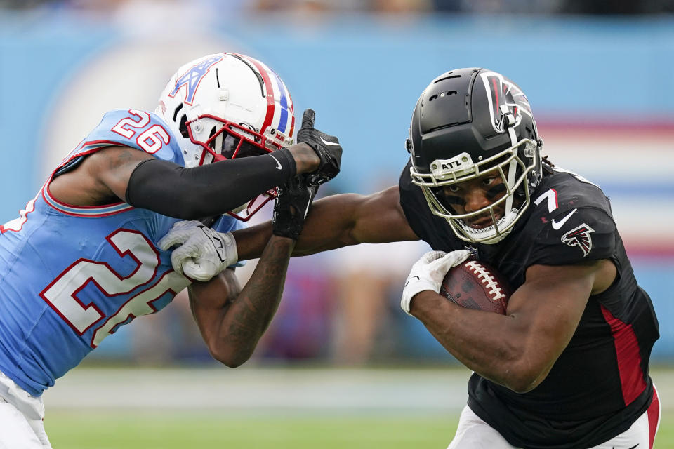 Atlanta Falcons running back Bijan Robinson (7) fends off Tennessee Titans cornerback Kristian Fulton (26) during the second half of an NFL football game, Sunday, Oct. 29, 2023, in Nashville, Tenn. (AP Photo/George Walker IV)