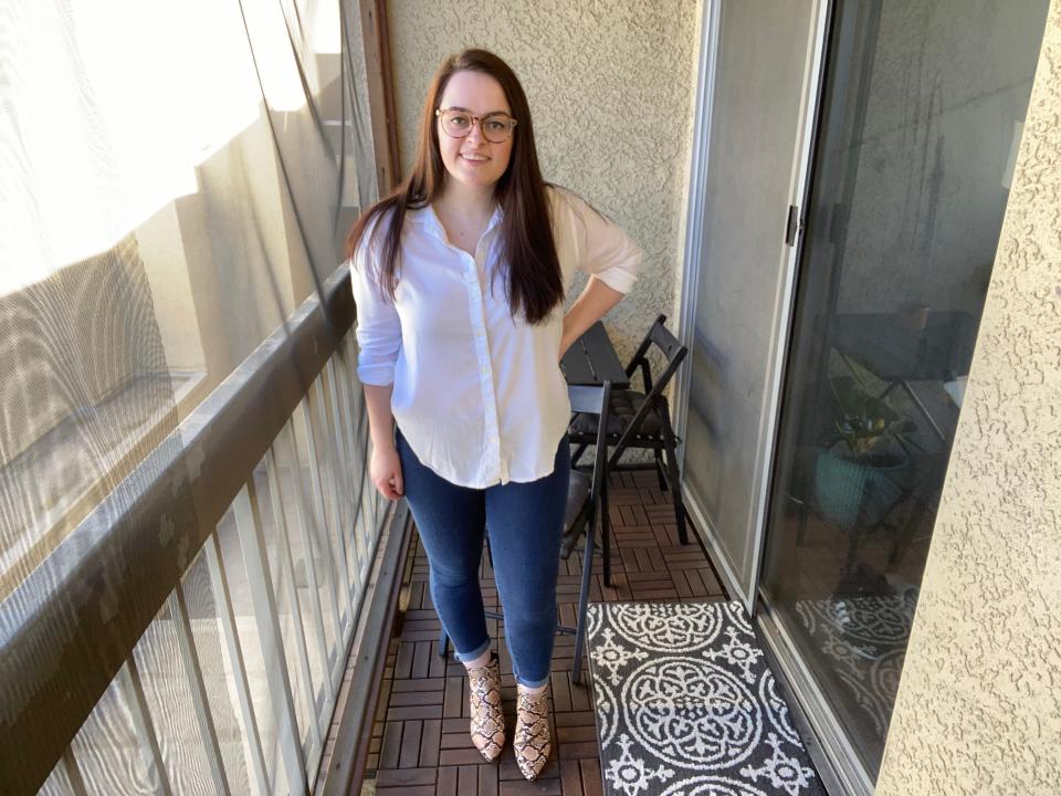 the writer on a balcony wearing white button down, dark pants, and snakeskin boots on a hardwood floor