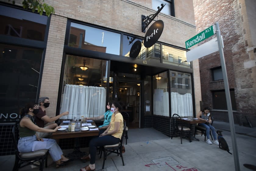 PASADENA, CA - JULY 08: Patrons enjoy dinner outside Perle Restaurant Wednesday, July 8, 2020 in Pasadena, CA. Perle Restaurant is a new French restaurant that just opened in Pasadena. They are doing take out and have a few tables outside their front door. With coronavirus surging, bars, indoor dining could remain closed for the foreseeable future. (Francine Orr / Los Angeles Times)