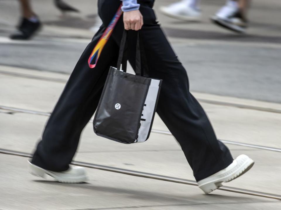  A pedestrian walks with a Lululemon Athletica Inc. shopping bag in Toronto.