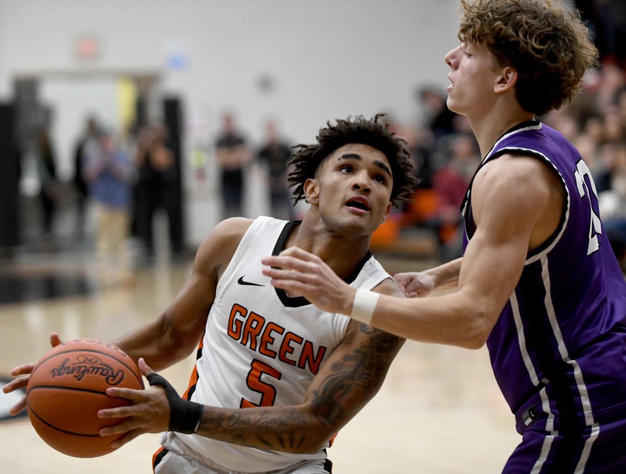 Green guard Antonio Martin (5) drives to the basket as Jackson guard Anthony Fuline defends during a game in December.