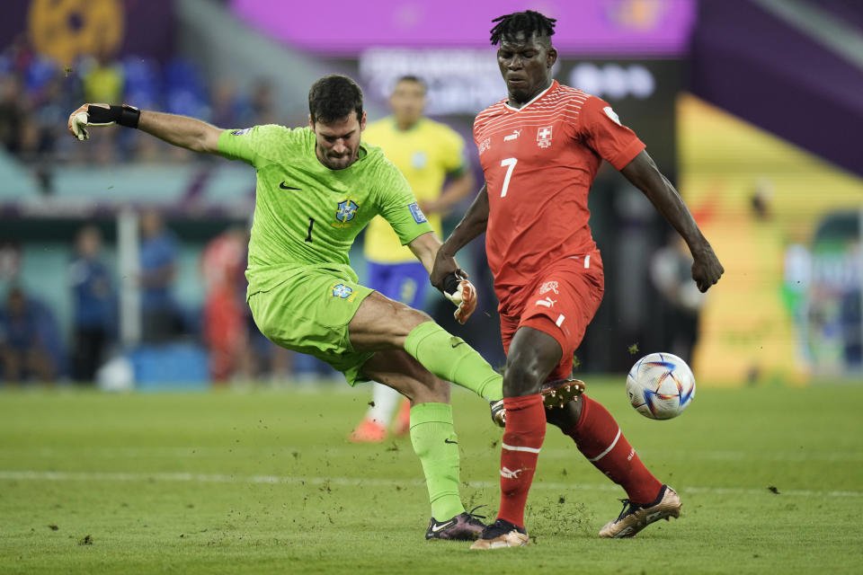 Brazil's goalkeeper Alisson, left, and Switzerland's Breel Embolo challenge for the ball during the World Cup group G soccer match between Brazil and Switzerland at the Stadium 974 in Doha, Qatar, Monday, Nov. 28, 2022. (AP Photo/Hassan Ammar)