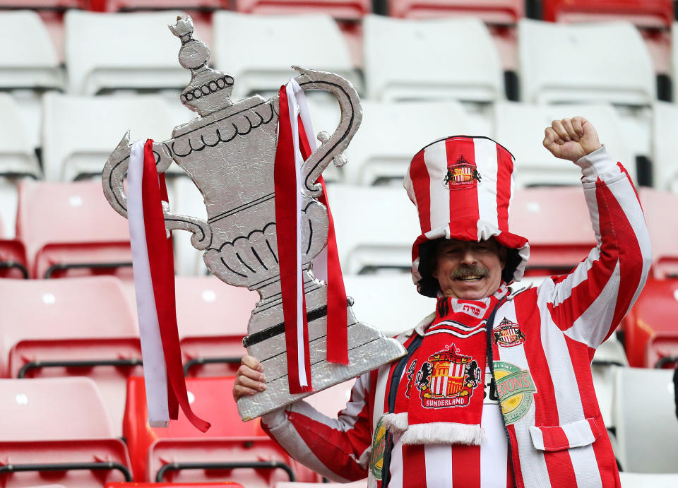 Sunderland supporter George Slough holds a cardboard FA Cup at the end of their English FA Cup fifth round soccer match against Southampton at the Stadium of Light, Sunderland, England, Saturday, Feb. 15, 2014. (AP Photo/Scott Heppell)