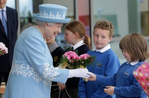 Britain's Queen Elizabeth II is given flowers during a visit to the South West Acute Hospital in Enniskillen, Northern Ireland, on June 26. The British monarch is poised to make a historic gesture in Northern Ireland's peace process when she shakes the hand of former IRA commander Martin McGuinness