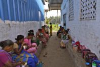 Workers break for lunch outside a tin-roofed processing shed in the hamlet of the Tallarevu, in Kakinada district, in the Indian state of Andhra Pradesh, Sunday, Feb. 11, 2024. (AP Photo/Mahesh Kumar A.)