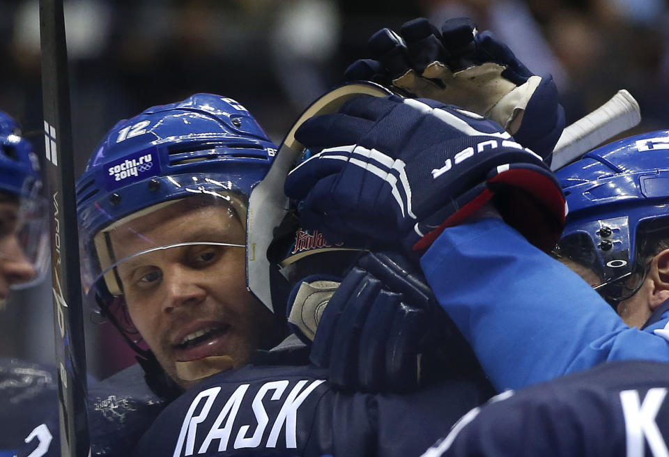 Finland forward Olli Jokinen congratulates Finland goaltender Tuukka Rask after Finland beat Russia 3-1 in a men's quarterfinal ice hockey game at the 2014 Winter Olympics, Wednesday, Feb. 19, 2014, in Sochi, Russia. (AP Photo/Julio Cortez)