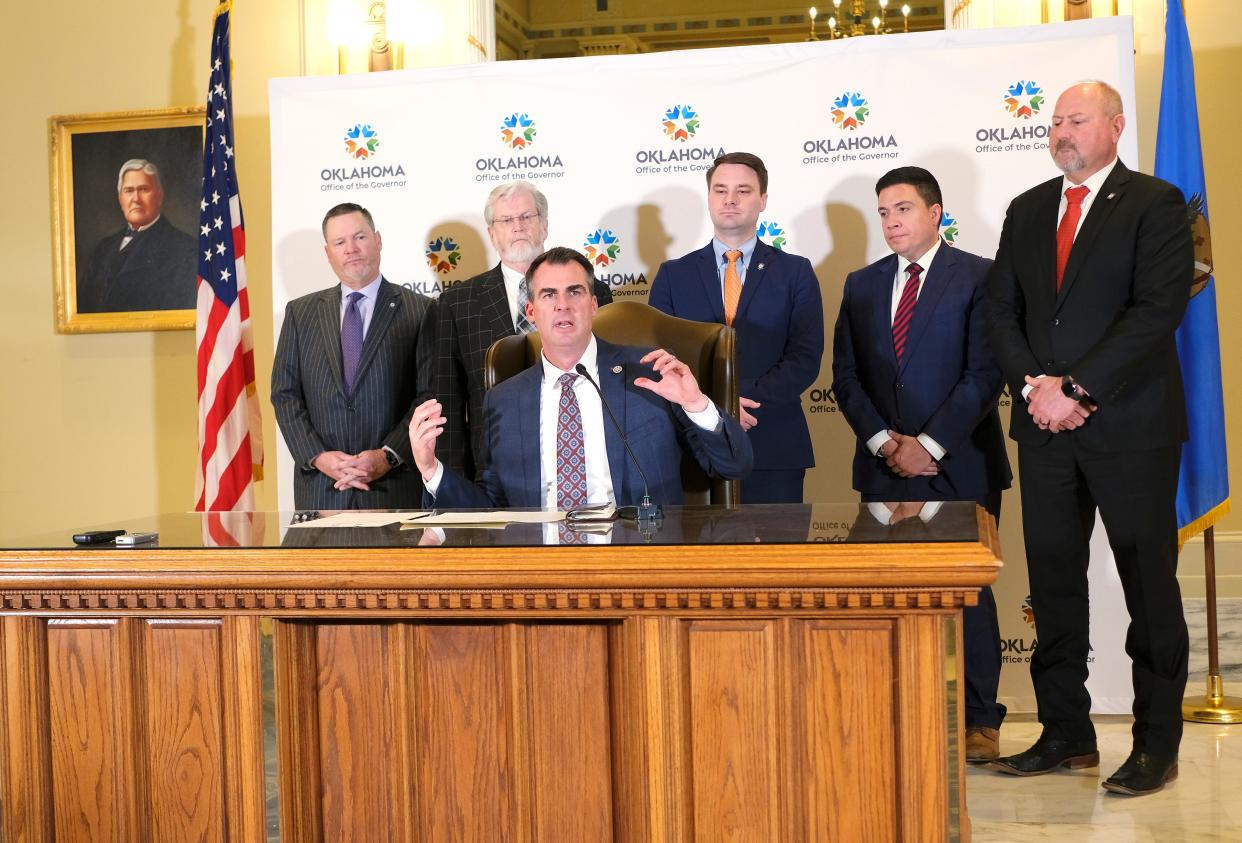 Oklahoma Gov. Kevin Stitt signs the LEAD Act on Thursday in the Blue Room at the Capitol with members of the House and Senate behind him: From left, Sen. Chuck Hall, Sen. Roger Thompson, Speaker Pro Tempore Rep. Kyle Hilbert, Rep. Ryan Martinez and Rep. Kevin Wallace.