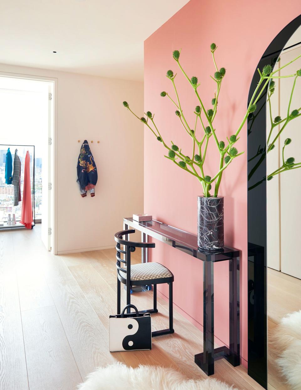 In the home’s foyer, rose-tinted walls as well as a vintage Joseph Hoffman chair and a black acrylic console from Interlude Home help create a feminine, retro atmosphere. In the back is Angelo’s office, which features a distinctive clothing rack from Plinths.London with black metal rails and a microsuede base. The stylist and creative director is getting ready to launch her own clothing line, Angelilli, in the fall.