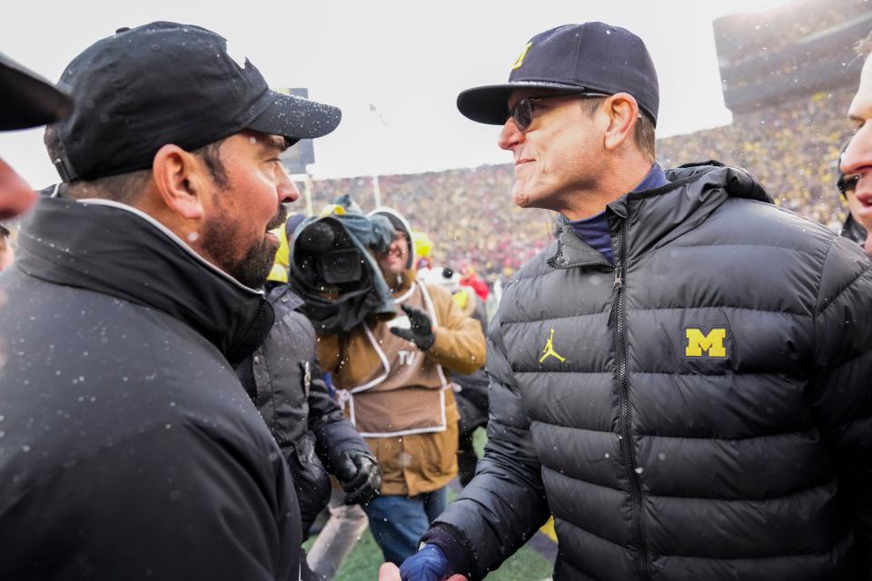 Ohio State Buckeyes head coach Ryan Day shakes hands with Michigan Wolverines head coach Jim Harbaugh following the NCAA football game at Michigan Stadium in Ann Arbor on Saturday, Nov. 27, 2021. Michigan won 42-27.